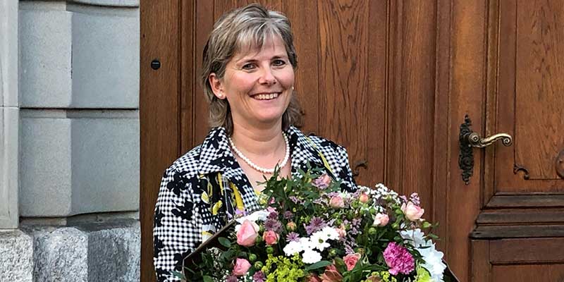 Alexandra Beck mit Blumenstrauss vor der Türe des Rathauses in Weinfelden
